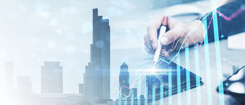 Wide image of office workplace with close up of male hands using device and forex chart on creative blurry city background. Landing page background, trade and finance concept. Double exposure.