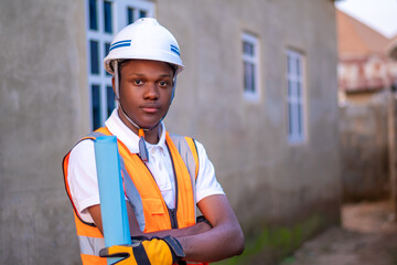 Close-up young african man construction worker standing in safety helmet and reflective jacket...