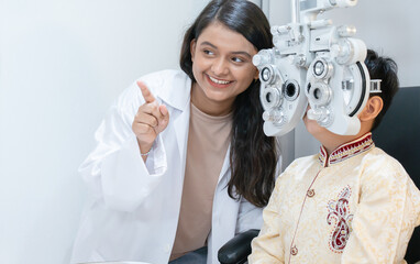 Indian child boy doing subjective refraction with diagnostic ophthalmology equipment, phoropter...