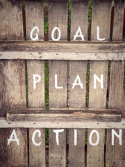 Goal, plan, action text on wooden surface background. Inspirational and motivational concept.