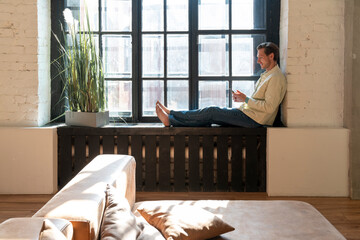 Mature man using smart phone at home