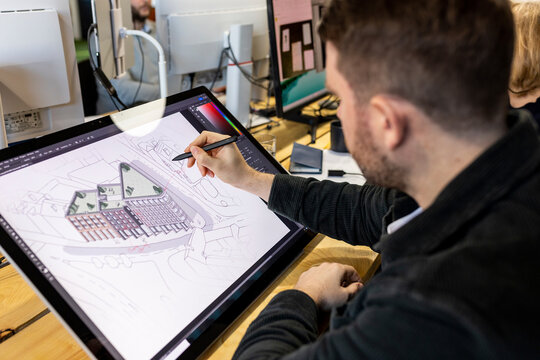 Architect working on graphics tablet at desk in office