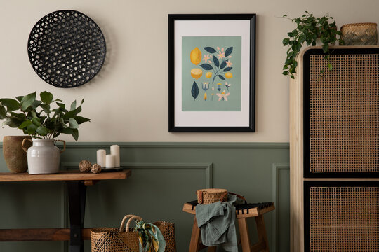 Interior design of spring living room interior with mock up poster frame, wooden bench, rattan sideboard, vase with leaves, candle and personal accessories. Homne decor. Template.