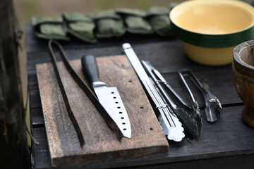 Cooking equipment for camping trip on wooden table. Camping utensils and outdoor recreation concept