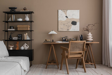 Interior design of aesthetic composition of workspace interior with mock up poster frame, wooden desk, rattan chair, modular sofa, stylish lamp and personal accessories. Home decor. Template.