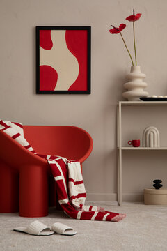 Modern composition of colorful living room interior with mock up poster frame, red armchair, plaid, vase with flowers, slippers, sculpture and personal accessories. Home decor. Template.
