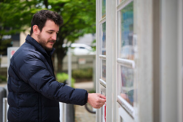 European tourist buying a drink in a japanese vending machine, jidouhanbaiki, in Kyoto, Japan.