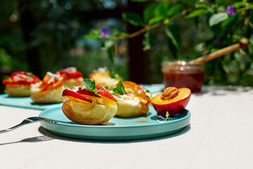 Mini sandwiches with cream cheese, nectarines, coconut, mint and honey. Delicious summer peaches toast, healthy lunch idea.