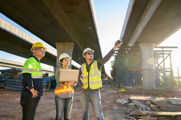 A team of civil engineer with architects and industrial construction workers on road construction site. Engineer team concept.