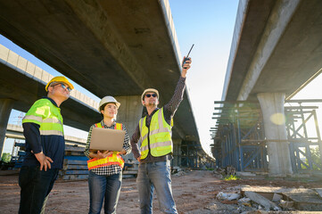 Construction engineer talking to architect at industrial construction site in road construction site