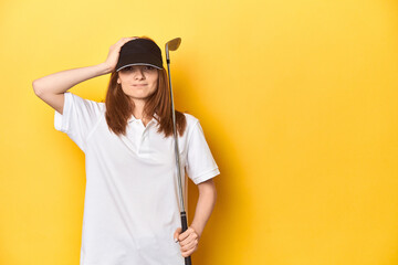 Redhead golfer with club and cap, studio shot being shocked, she has remembered important meeting.