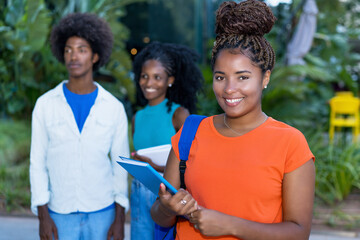 Pretty african american female student with group of black young adults