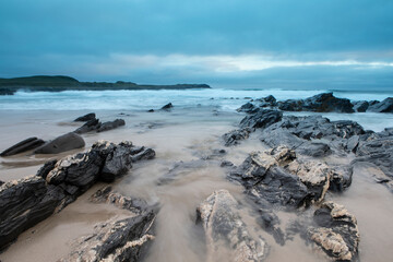 Rock formations along the beach at Saligo Bay in Isle of Islay, Scotland.