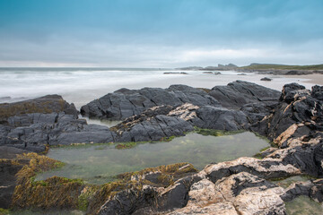 A rocky pool of water on a beach in the Isle of Islay.