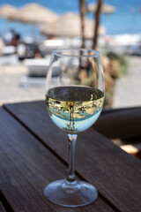 A glass of white wine at a restaurant by the beach in Kamari, Santorini. Greece
