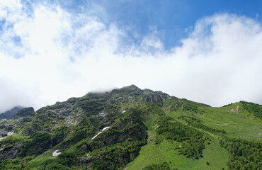 Fototapeta premium Summer landscape with green mountains against cloudy sky. beautiful scenic nature view with mountains. natural background. trip, journey, hiking, adventure concept. Caucasus mountains, Arkhyz