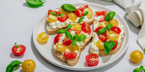 Fresh bread sandwiches with tomato cherry, cream cheese and basil leaves. Morning breakfast concept
