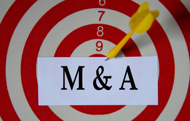 M and A - acronym on a white piece of paper on the background of a target for dards