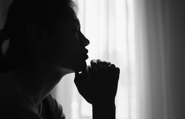 Silhouette of Religious young woman praying to God in the morning, spirtuality and religion, ...