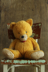 vintage teddy bear on an old chair with a paint peeling off