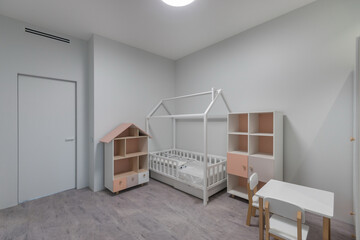 Children's room with installed furniture. Cabinets with shelves and drawers for the use of the baby.