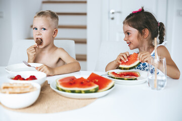 Two kids eating fresh juicy watermelon and ice-cream