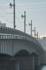 Road bridge in the historic city with street lamps in the early morning in the fog, faded image.