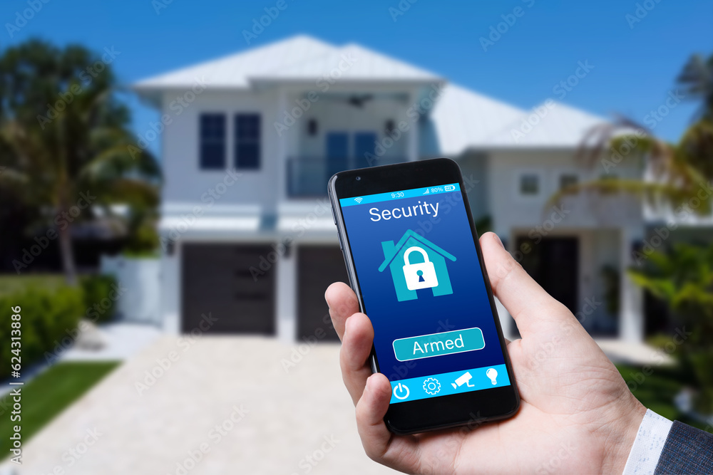 Poster smartphone with home security app in a hand on the building background.