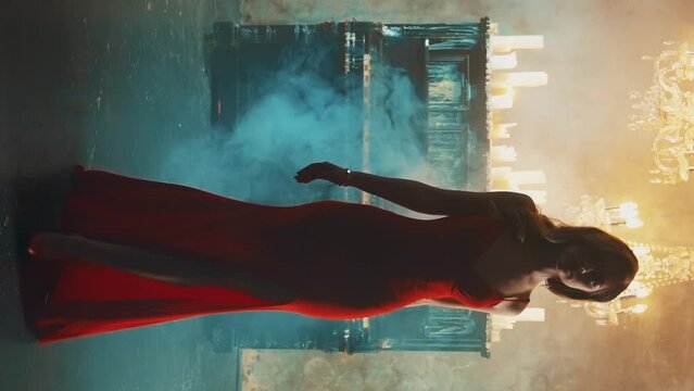 Dark Silhouette fantasy lady gothic woman blond hair walks in luxurious room black piano candles. Evening dress slit on leg fashion model long red dress sexy girl vampire queen art vertical video crop