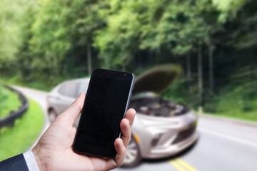 Man use mobile phone, blur image of the car is broken down as background.