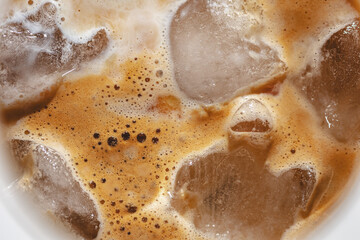 Texture Iced espresso coffee to wineglass with ice, top view, hard light