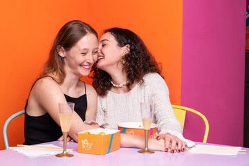 Attractive couple of casual caucasian girls eating delicious poke, japanese fresh healty food,...