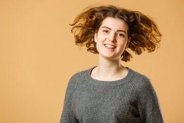 Close up portrait of young happy woman on beige background