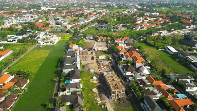 Aerial over Canggu showing the increased urban expansion due to unrestricted tourism.  This is causing pollution, overpopulation and traffic problems. Drone orbit shot
