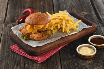 Tasty crispy chicken burger with crispy hamburger buns, cheddar cheese,ketchup,mayonnaise and french fries