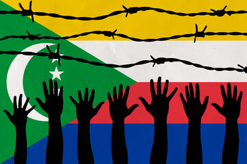 Comoros flag behind barbed wire fence. Group of people hands. Freedom and propaganda concept