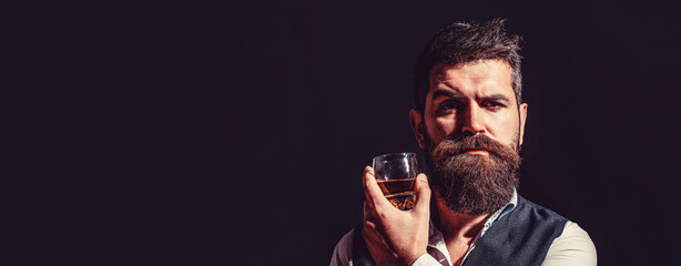 Sipping whiskey. Portrait of man with thick beard. Macho drinking. Man beard holds glass brandy....