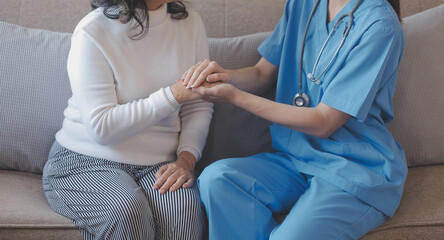 Cropped shot of a female nurse hold her senior patient's hand. Giving Support. Doctor helping old patient with Alzheimer's disease. Female carer holding hands of senior man