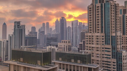 Fototapeta na wymiar Dubai skyscrapers with golden sunset over business bay district timelapse.