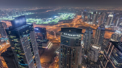 Panorama of Dubai Marina with JLT skyscrapers and golf course night timelapse, Dubai, United Arab Emirates.