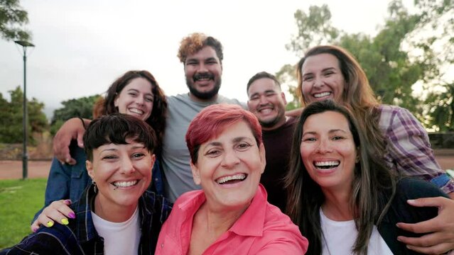Multi generational people taking selfie outside - Happy group of friends having fun together outdoor at park city - Friendship and diversity community concept