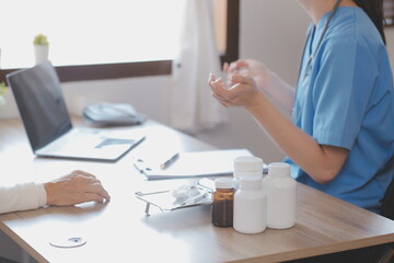 Doctor and patient talking while sitting at the desk in hospital office, closeup of human hands. Medicine and health care concept