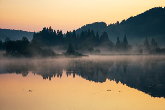 lever de soleil et brume matinale sur le lac de Lamoura dans le Haut Jura en France