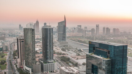 Fototapeta premium Aerial view of media city and al barsha heights district area night to day timelapse from Dubai marina.