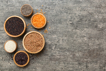 Various superfoods in smal bowl on colored background. Superfood as rice, chia, quinoa, lentils, nuts, sesame seeds, almonds. top view copy space
