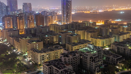 Skyscrapers in Barsha Heights district and low rise buildings in Greens district aerial all night timelapse.
