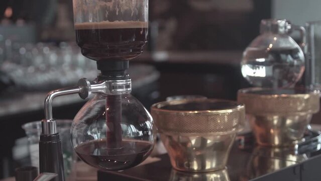Preparing coffee with syphon at coffee shop.