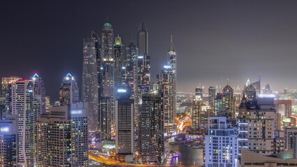 Naklejka premium View of various skyscrapers in tallest recidential block in Dubai Marina aerial day to night timelapse