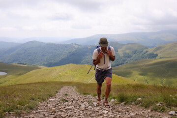 Mountain trekker: Tourist hiking high in the mountains.Man traveler with backpack is hiking in mountain.Traveling in nature. Baiului Mountains trails. Carpathians mountains in Romania. 