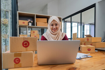 Muslim beautiful woman in hijab working online sales Checking for customer orders in office